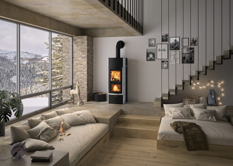 Wassergeführter Kaminofen Hektos Aqua mit Dual-Fire Technologie mit doppelter Brennkammer in Wohnzimmer. Modernes Sofa und Kinderspielecke im Bild. Betontreppe mit Bildergalerie im Hintergrund.
