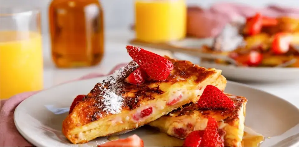 Auf dem Bild siehts du Gefüllte Arme Ritter mit frischen Erdbeeren auf einem weißem Teller angerichtet