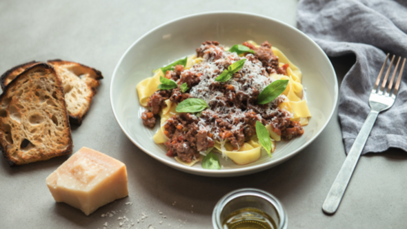 Auf dem Bild sieht man eine Klassische Bolognese auf einem grauen Teller angerichtet