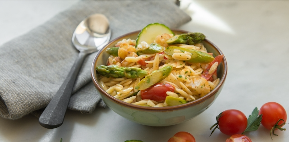 Auf dem Bild sieht man Orzo-Nudeln mit Gemüse in einer olivfarbenden Schüssel.