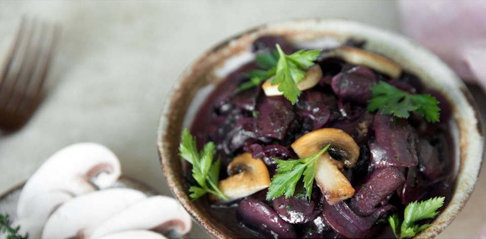 Das Bild zeigt ein Rotwein-Pilz-Ragout in einer grauen Schüssel angerichtet